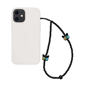 Détail de la dragonne de téléphone en perles noires avec breloques de chat aux yeux vairons