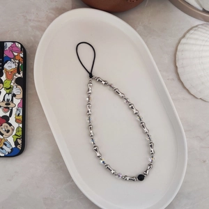 Handmade beaded phone strap with silver metallic and crystal beads on a ceramic tray