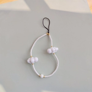 Detailed macro view of white beaded phone strap with cloud charms and gold bead accents