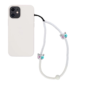 Détail du bijou de téléphone en perles blanches avec breloques de chat argentées et yeux
