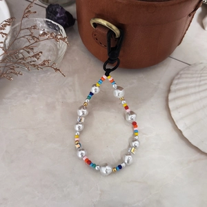 Rainbow beaded keychain with baroque pearls and colorful beads hanging on a leather bag