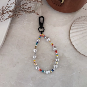 Handmade rainbow beaded keychain with baroque pearls and colorful beads on marble