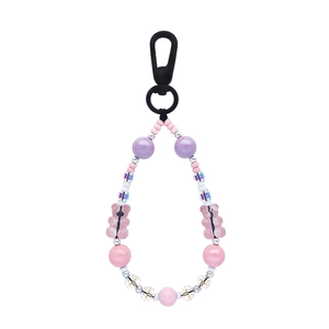 Pink and purple beaded crystal skull keychain with cute bear charms on white background