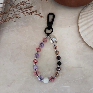 Colorful beaded keychain with skull and star charms on an elegant marble background