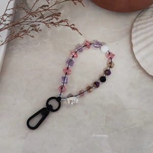 Colorful crystal beaded keychain with skull pendant on marble background for bags