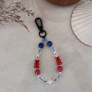 Detail of beaded keychain with cute red bear pendant and colorful resin beads