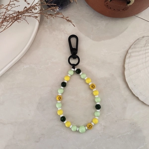 Lime green and yellow beaded keychain with smiley face charms and a black matte carabiner