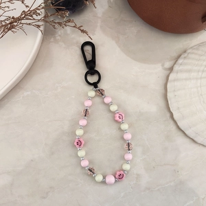 Porte-clés artisanal en perles avec fleurs souriantes roses et mousqueton noir