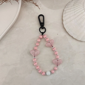 Detail of pink striped acrylic beads and translucent heart charm on a beaded keychain