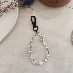 Macro detail of handmade crystal beads and silver irregular charms on a keyring