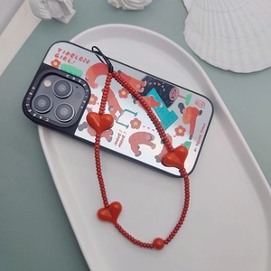 Red heart bead phone strap and illustrated phone case on a white decorative tray