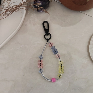 Détail de perles d'ours en acrylique colorées sur un cordon fait main avec décor