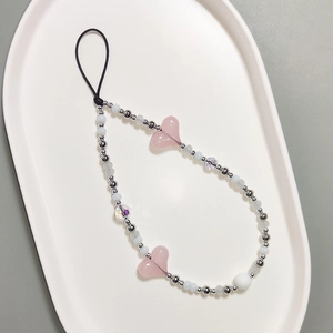 Cordino per cellulare con perline, cuori rosa e sfere metalliche su vassoio bianco