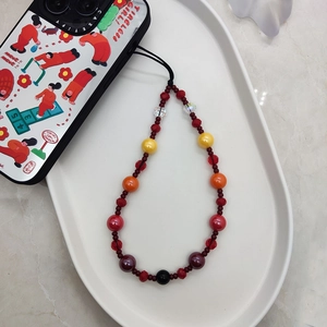 Colorful beaded phone charm wrist strap featuring vibrant crystal beads on white tray