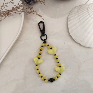 Detail of beaded heart keychain with striped patterns and black lobster clasp