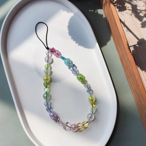 Colorful acrylic heart-shaped beaded phone charm strap on a white display tray