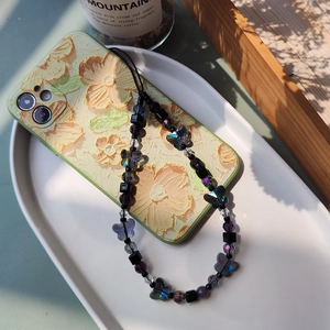 Beaded wrist strap for phone with black beads and iridescent butterfly on floral case