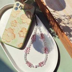 Pink gummy bear beaded phone wrist strap on floral case in aesthetic natural lighting