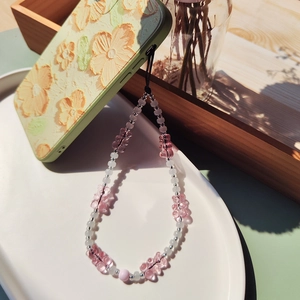 Handmade beaded phone strap with pink gummy bear charms on floral embossed phone case