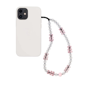 Cute pink gummy bear and matte clear beaded phone wrist strap on a white smartphone