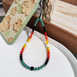 Handmade gradient glass beaded phone charm with colorful beads on a floral embossed case