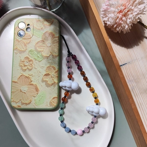 Floral relief phone case with colorful acrylic cloud beaded charm strap on white plate