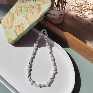 Beaded heart phone strap with iridescent crystals on a floral embossed case