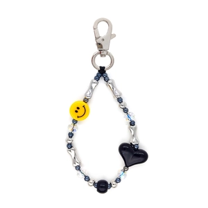 Handmade beaded keychain with silver bone beads, yellow smiley face, and black heart pendant