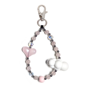 Close-up of pink acrylic beads with heart and white cloud charms on a beaded keychain