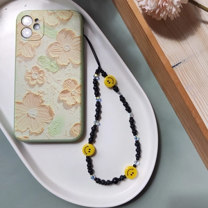 Detail of oil painting texture phone case with floral patterns and yellow smiley beads