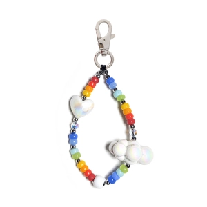 Detail of colorful beaded keychain with white pearl heart and cloud charms on white backdrop