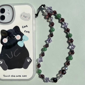 Purple crystal beaded phone strap with cute black cat pattern case on green leather surface