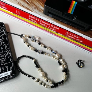 Dettaglio del cinturino per telefono fatto a mano con perle barocche e teschio di cristallo