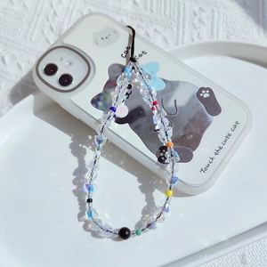 Close-up of handmade iridescent crystal beaded phone charm with colorful accents and rainbow light