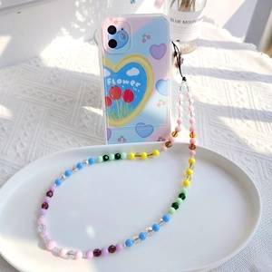 Detail view of colorful beaded lanyard and floral heart pattern smartphone case