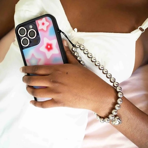 Detail of Y2K style smartphone case with silver beaded wrist strap and heart pendant