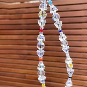 Close-up of colorful crystal glass beads and mixed colored seed beads on mobile phone strap