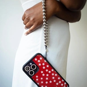 Detail of red star pattern phone case with silver beaded strap and diamond camera rings