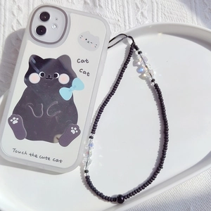 Detail view of cartoon cat phone case and handmade beaded lanyard on white tray