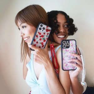 Close-up of handmade beaded phone strap with red berry charm and floral pattern case