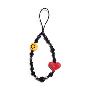 Detailed close-up of handmade beaded phone strap featuring red heart and bone-shaped beads