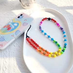 Detailed shot of rainbow beaded phone strap attached to a floral tulip patterned case