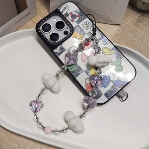 Detail of beaded phone strap with purple heart and cloud beads on white ceramic tray