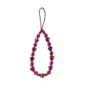 Detail of beaded phone strap with purple crystals, red beads, and a butterfly charm