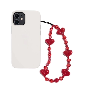 Detail of red beaded phone charm with acrylic heart pendants and transparent beads