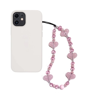Pink heart beaded phone charm with ceramic rainbow beads on white smartphone