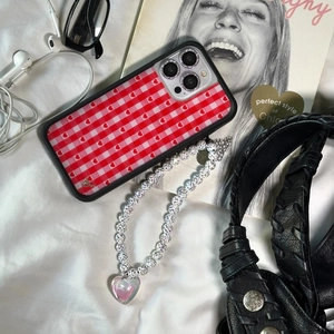Detail of red checkered heart phone case with pearl beaded lanyard and crystal charm