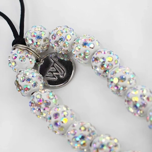 Macro detail of handmade beaded phone strap with shimmering rhinestones and metal logo tag