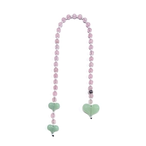 Macro detail of handmade beaded chain with purple acrylic beads and green heart charms