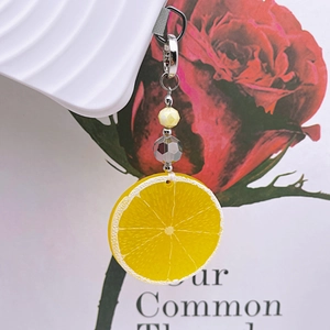 Detailed macro shot of a lemon slice acrylic keychain with beads and silver metal clip